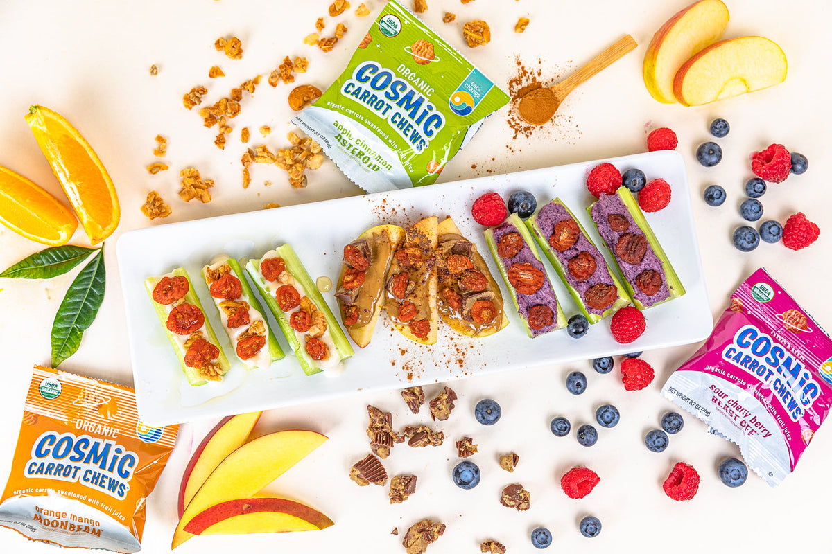 Bumps on a Log celery snacks with fruit, granola, and Cosmic Carrot Chews on a serving platter