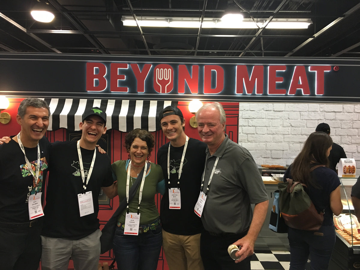 Five people pose together at a Beyond Meat trade show booth
